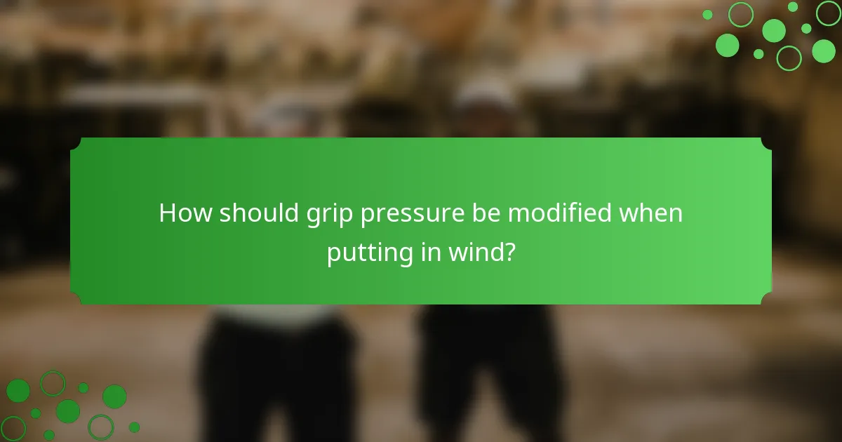 How should grip pressure be modified when putting in wind?