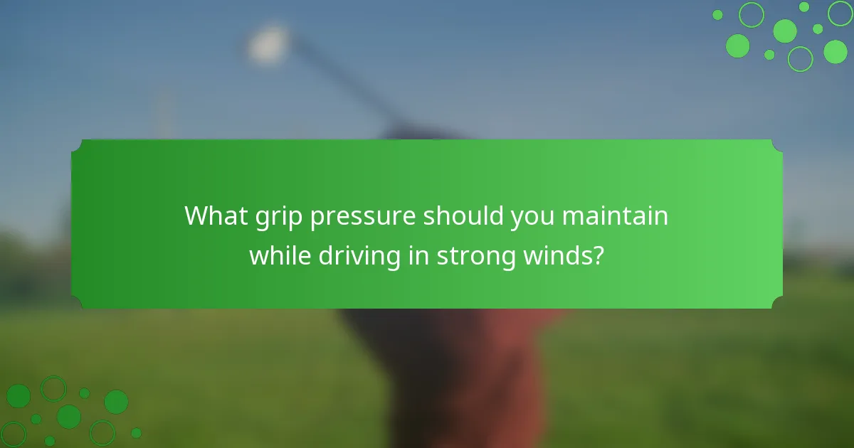 What grip pressure should you maintain while driving in strong winds?